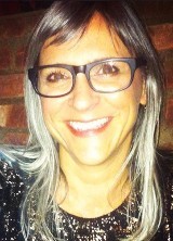 A smiling woman wearing black rim glasses